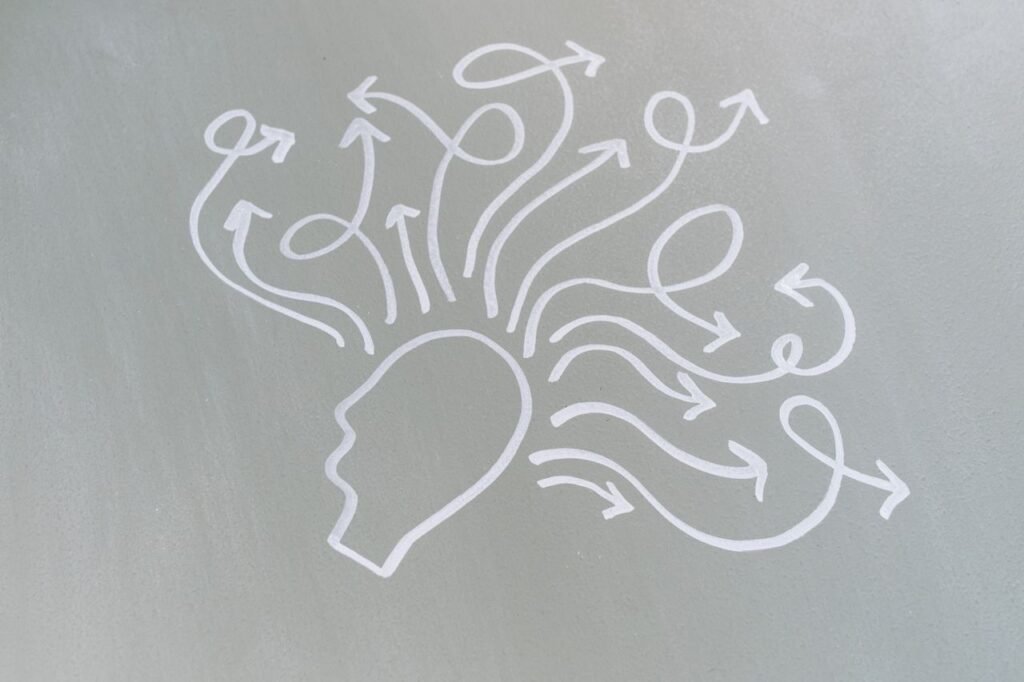 Chalk drawing of a head with swirling arrows represents mental activity and thought process.